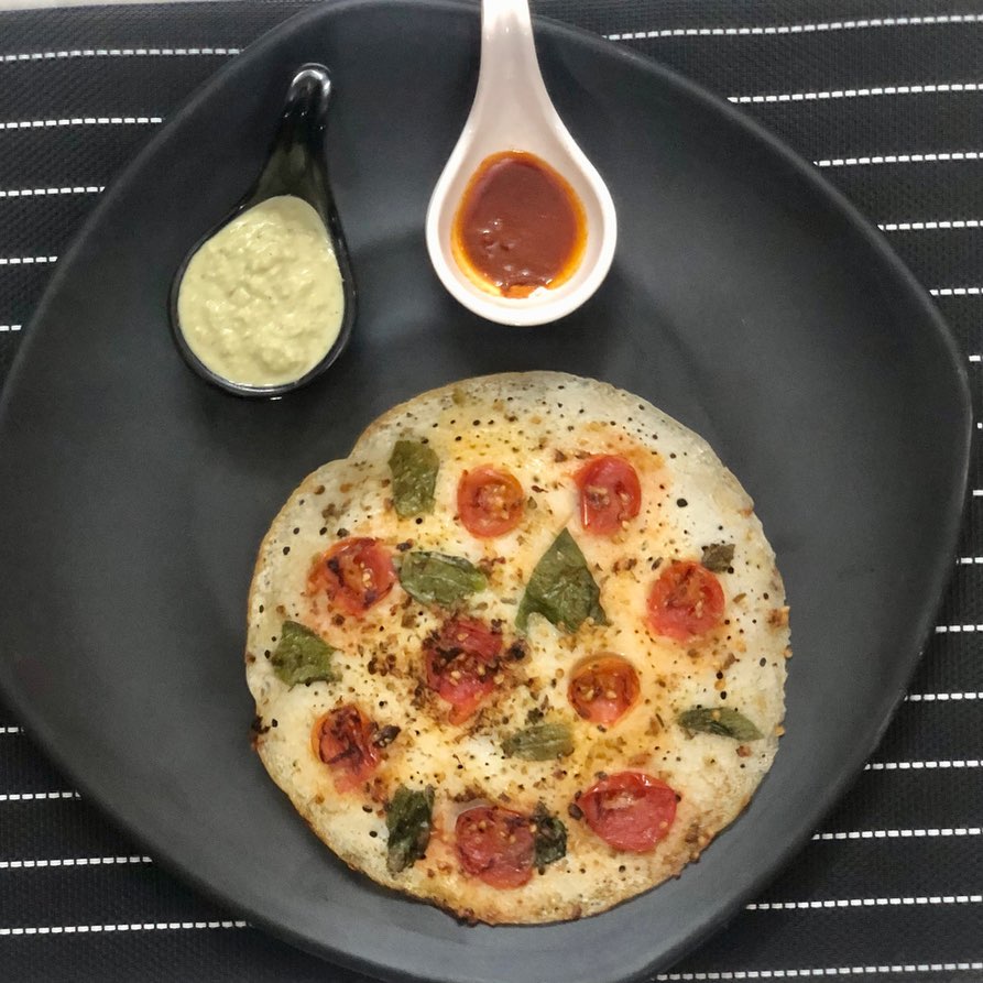 A combo of South Indian and Italian flavors : Uttapam Pizza!! ( uttapamizza) 
.
. 
Not only is it mouthwatering but also a healthier version of the usual greasy pizza 
.
.
All that I used for toppings was cherry tomatoes, basil and some Italian herbs

#uttapam #pizza #fusionfood #healthyrecipe #kpmeals